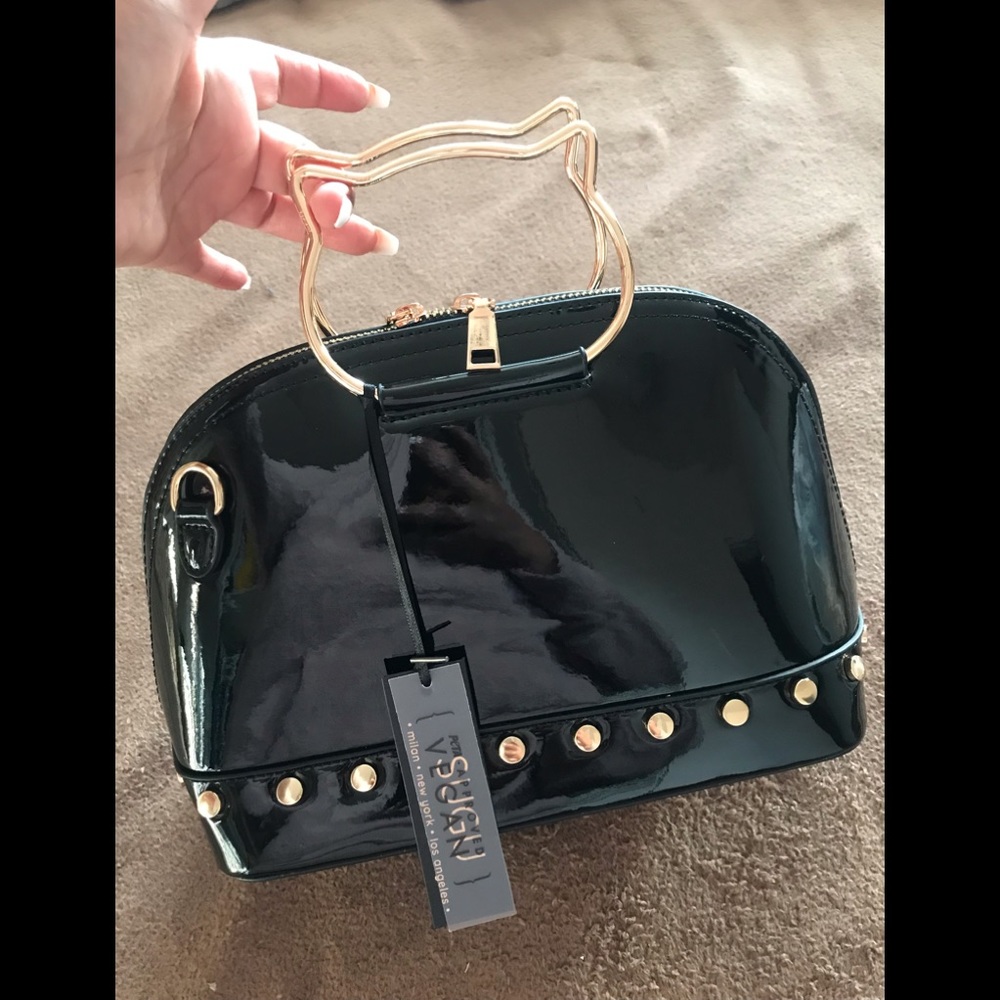 SUGU black satchel handbag featuring a distinctive gold-toned cat-shaped handle